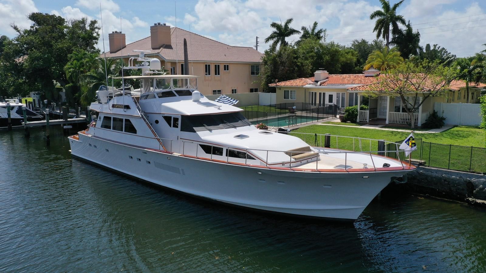 a white boat in a harbor aboard CAPTIVATOR Yacht for Sale