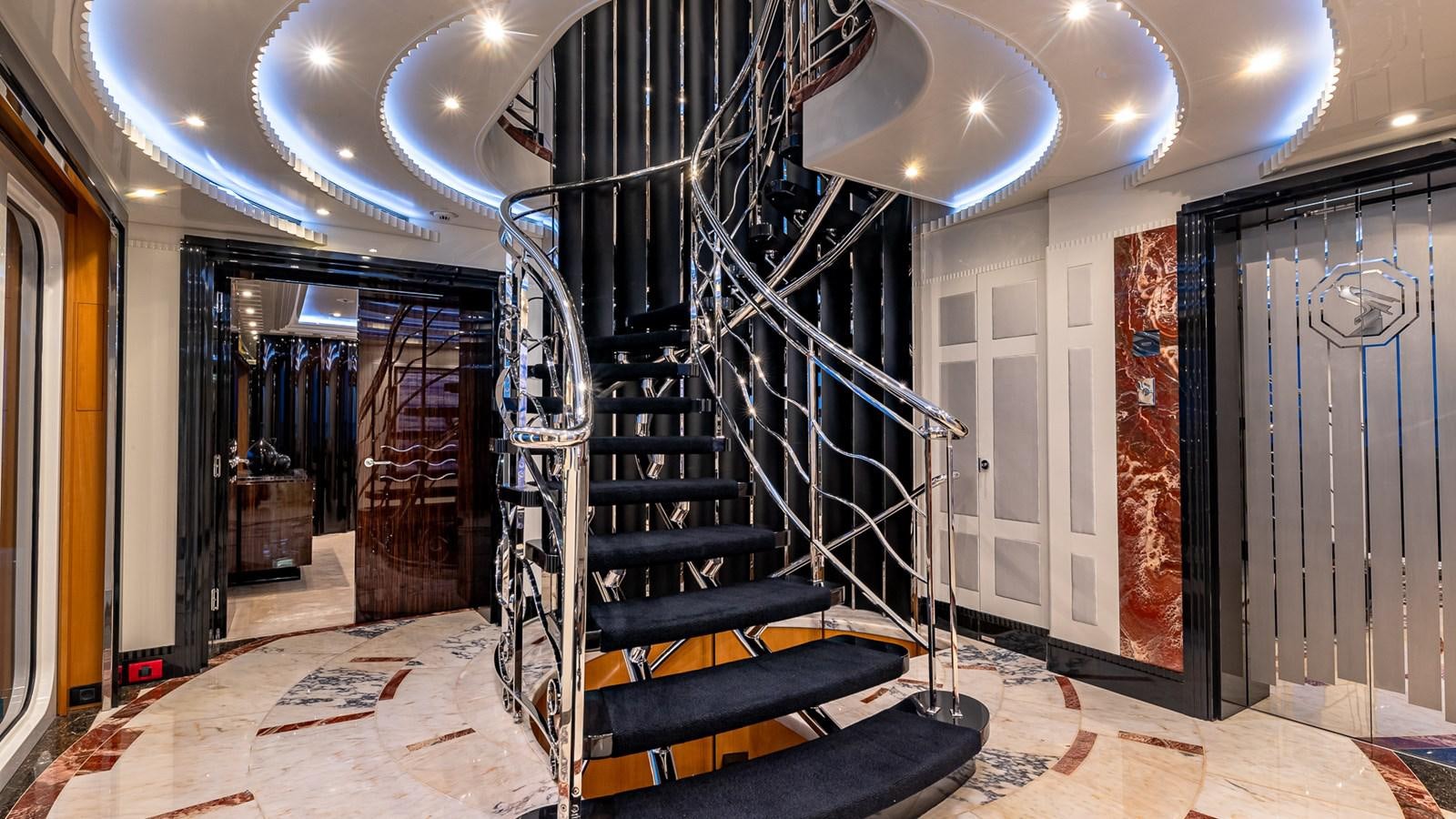 a black and blue staircase in a building with white walls aboard MARGUERITE Yacht for Charter