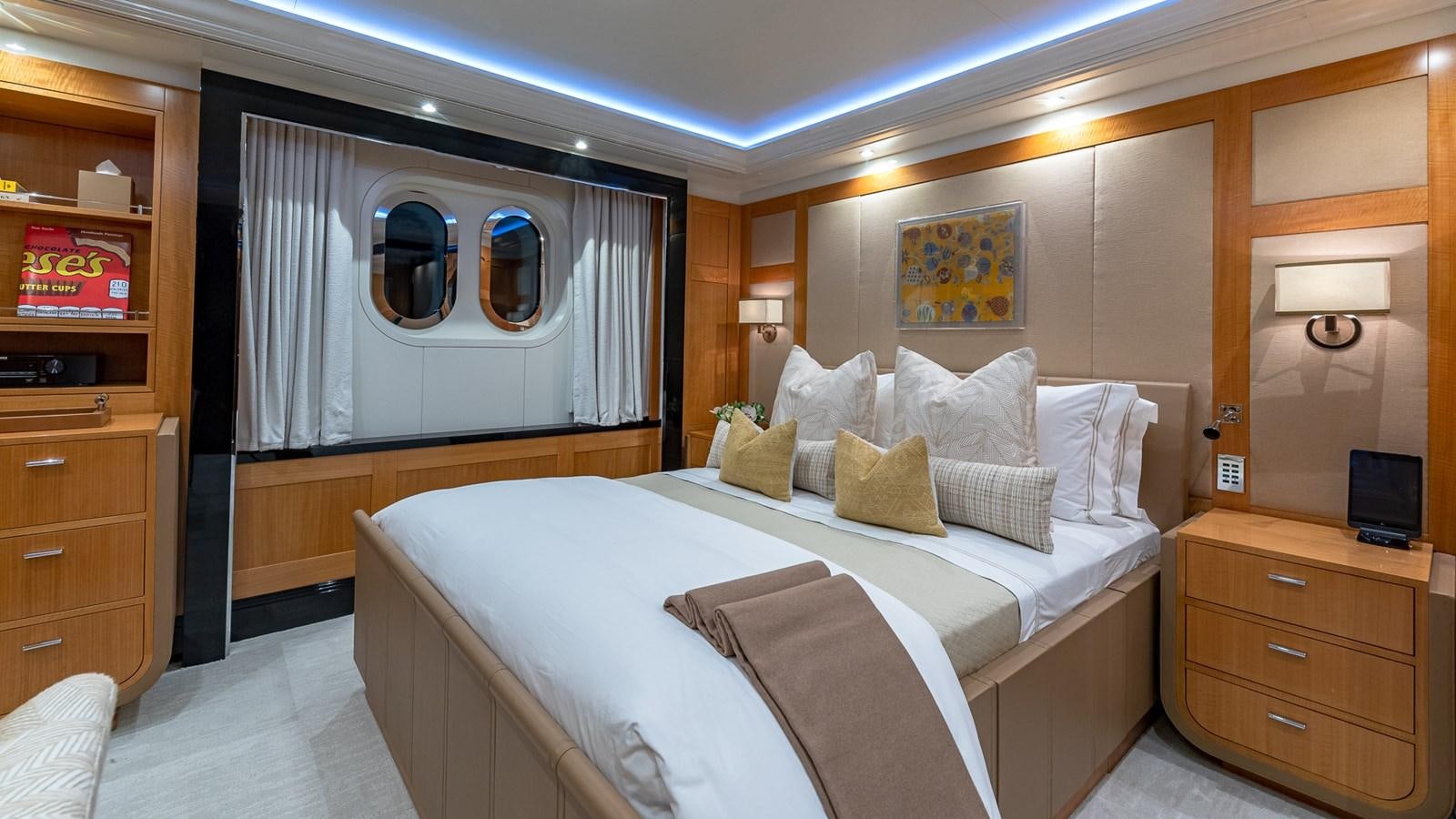 a bedroom with a bed and a dresser aboard MARGUERITE Yacht for Charter