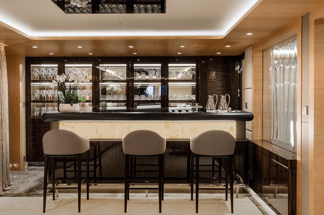 a large kitchen with a bar and stools aboard VICTORIOUS Yacht for Charter