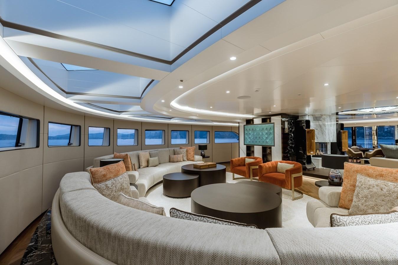 a living room with a large white couch and a large window aboard VICTORIOUS Yacht for Charter