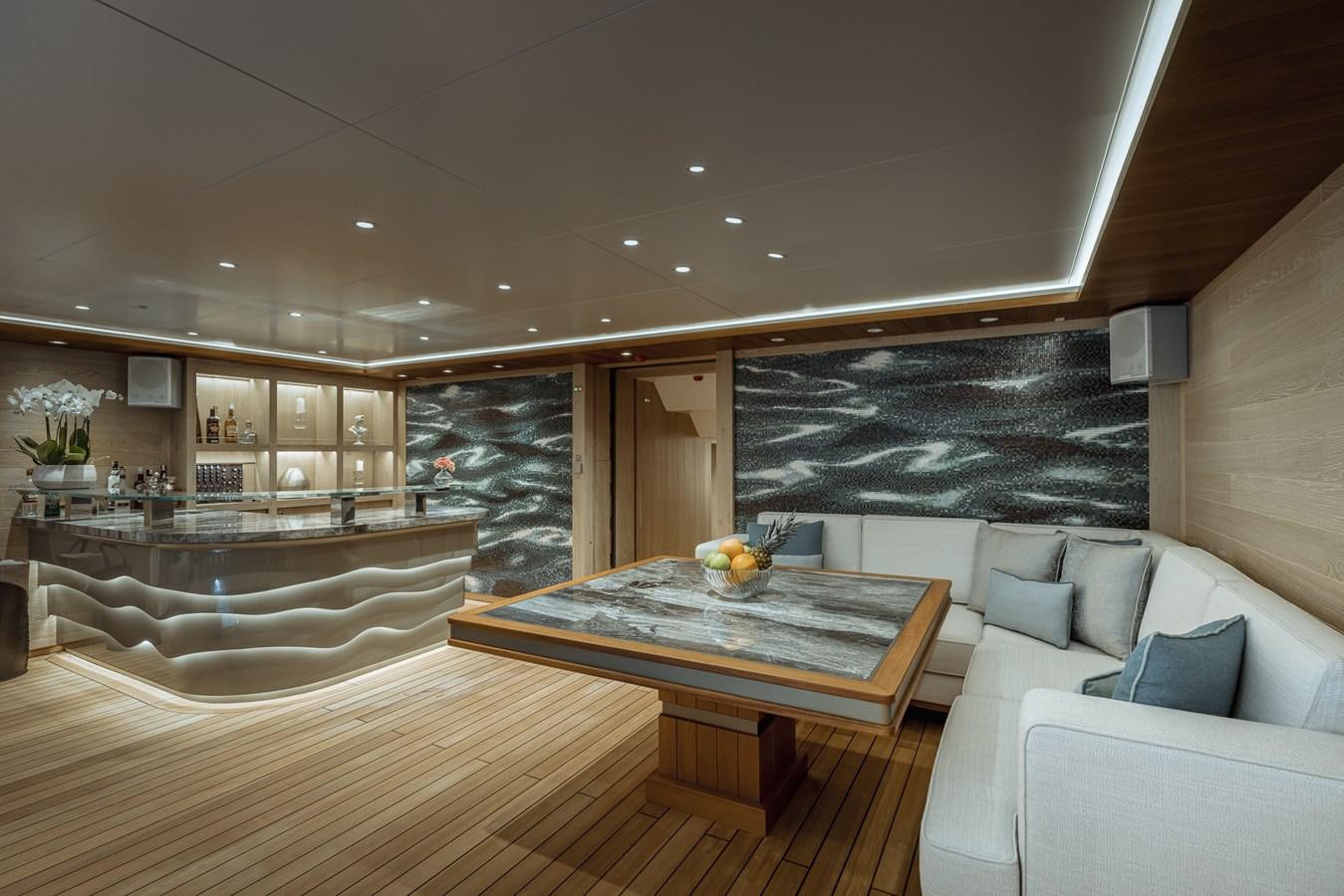 a living room with a large glass table and a large window aboard VICTORIOUS Yacht for Charter