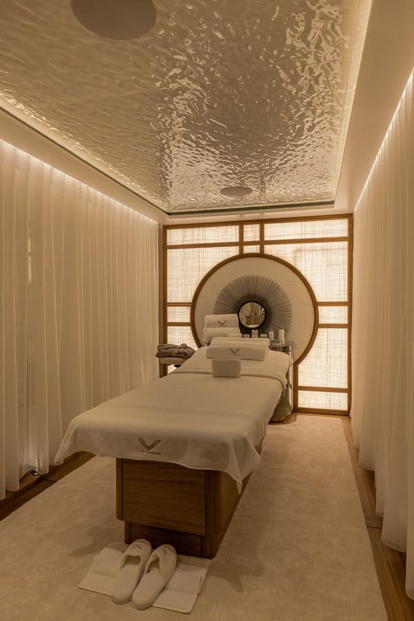 a room with a bed and fan aboard VICTORIOUS Yacht for Charter