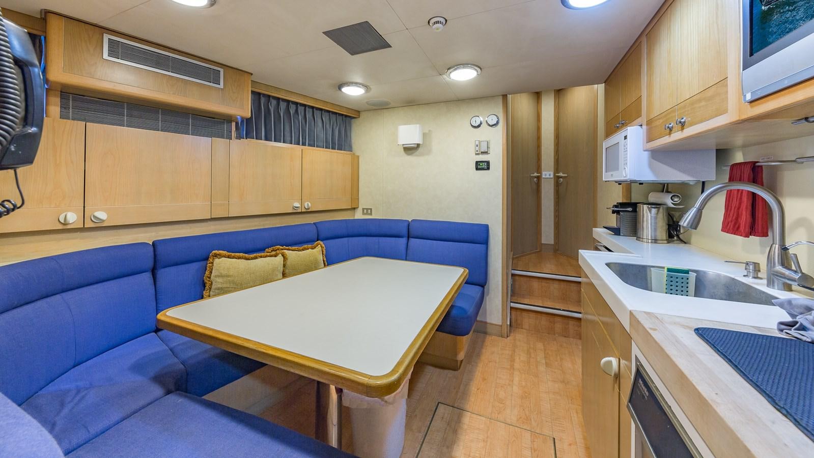 a kitchen with a blue couch aboard CASUAL WATER Yacht for Sale
