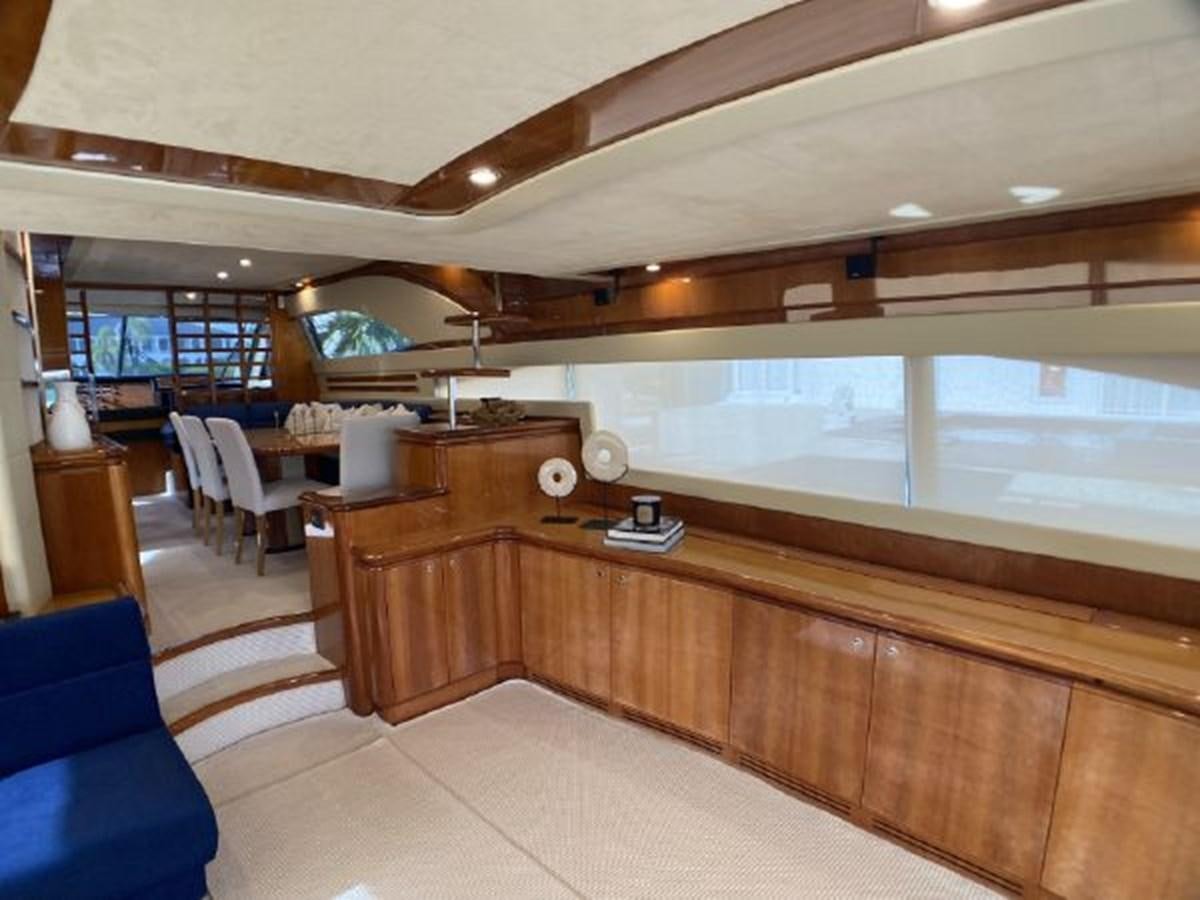a room with a wood floor and a wood desk with chairs and a large window aboard 2005 760 FERRETTI MOTOR YACHT Yacht for Sale