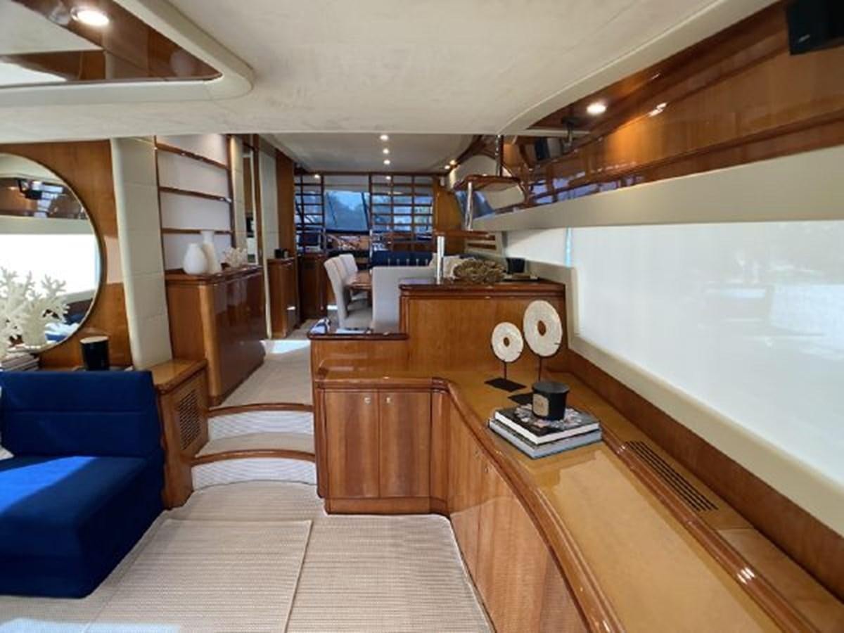 a room with a large window and a wood table with chairs and a large window aboard 2005 760 FERRETTI MOTOR YACHT Yacht for Sale