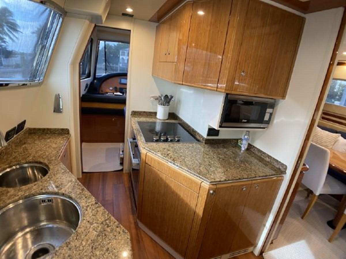a kitchen with wooden cabinets aboard 2005 760 FERRETTI MOTOR YACHT Yacht for Sale