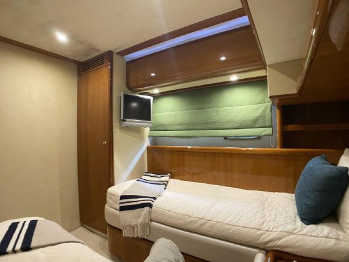 a room with a bed and a television aboard 2005 760 FERRETTI MOTOR YACHT Yacht for Sale