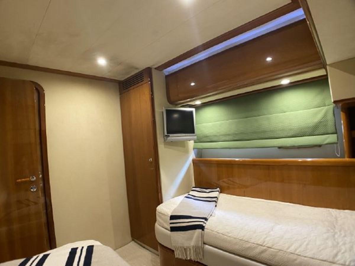 a room with a bed and a television aboard 2005 760 FERRETTI MOTOR YACHT Yacht for Sale
