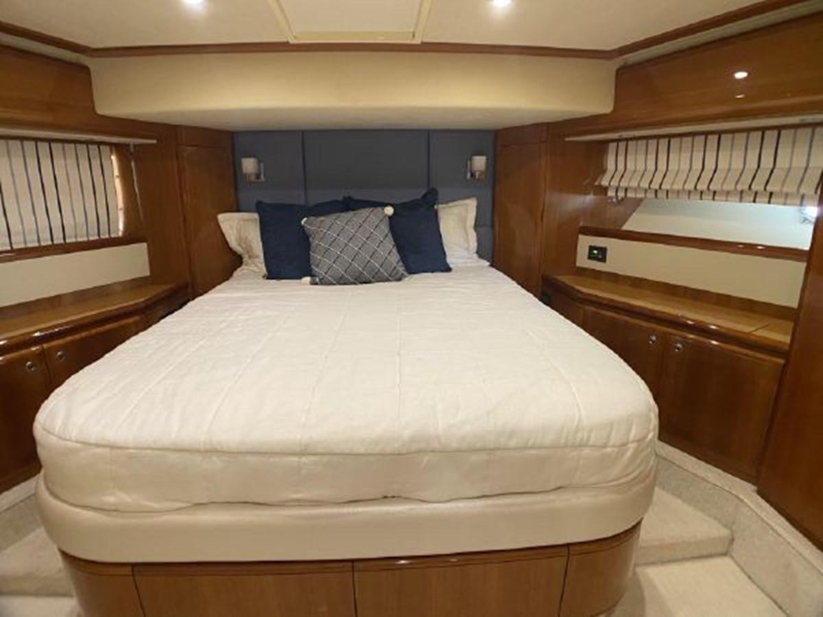 a bed with blue pillows aboard 2005 760 FERRETTI MOTOR YACHT Yacht for Sale
