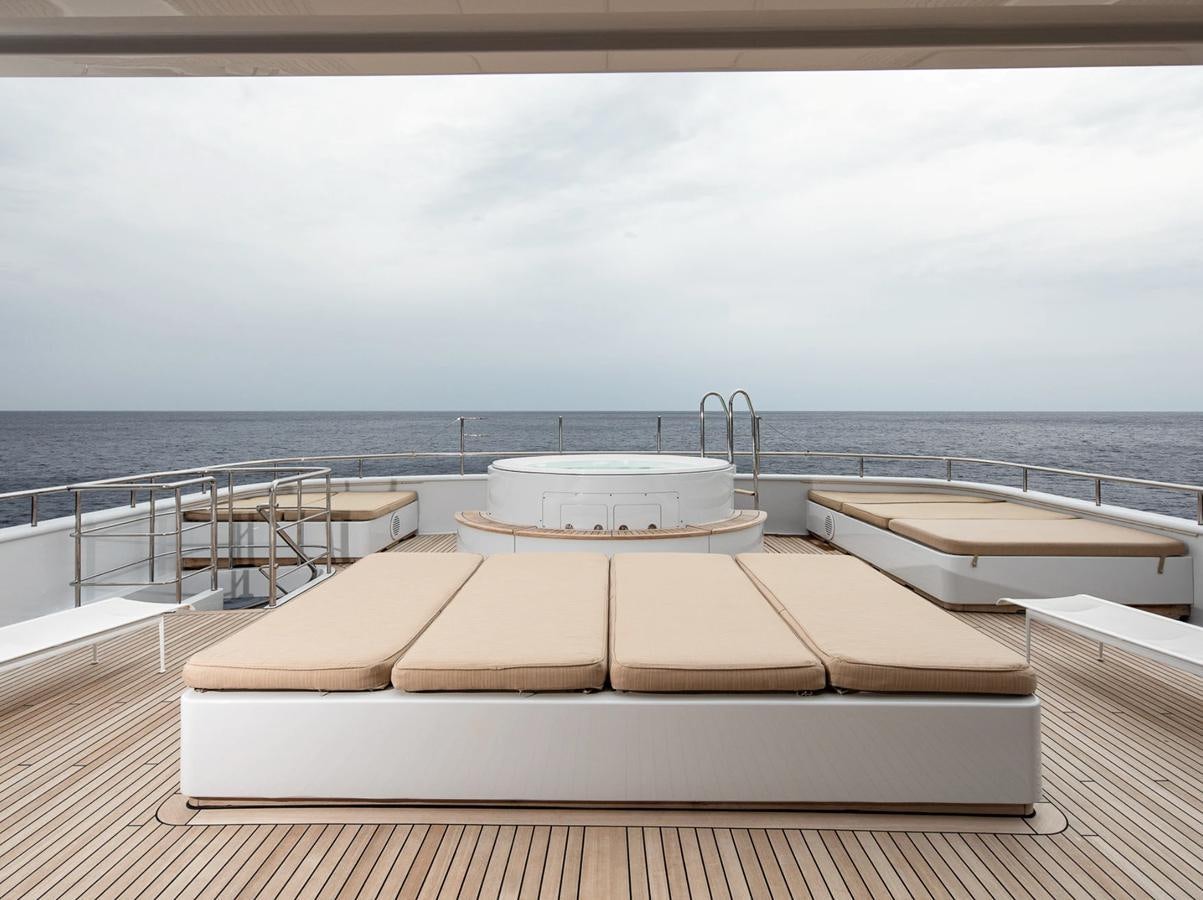 a lounge chair on a deck overlooking the ocean aboard MONEIKOS Yacht for Sale