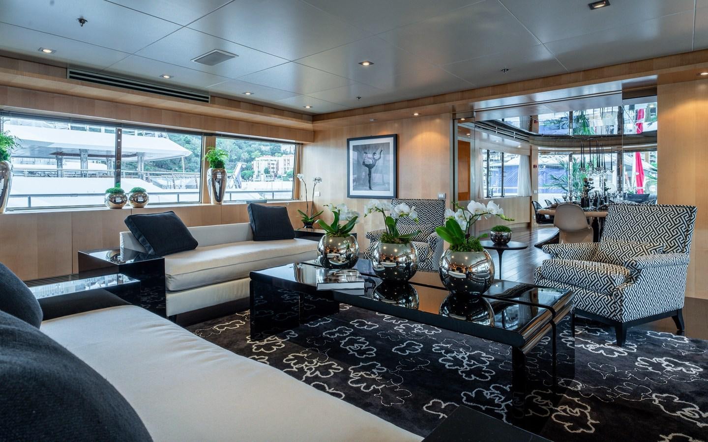 a living room with a large glass coffee table and a large window aboard MONEIKOS Yacht for Sale