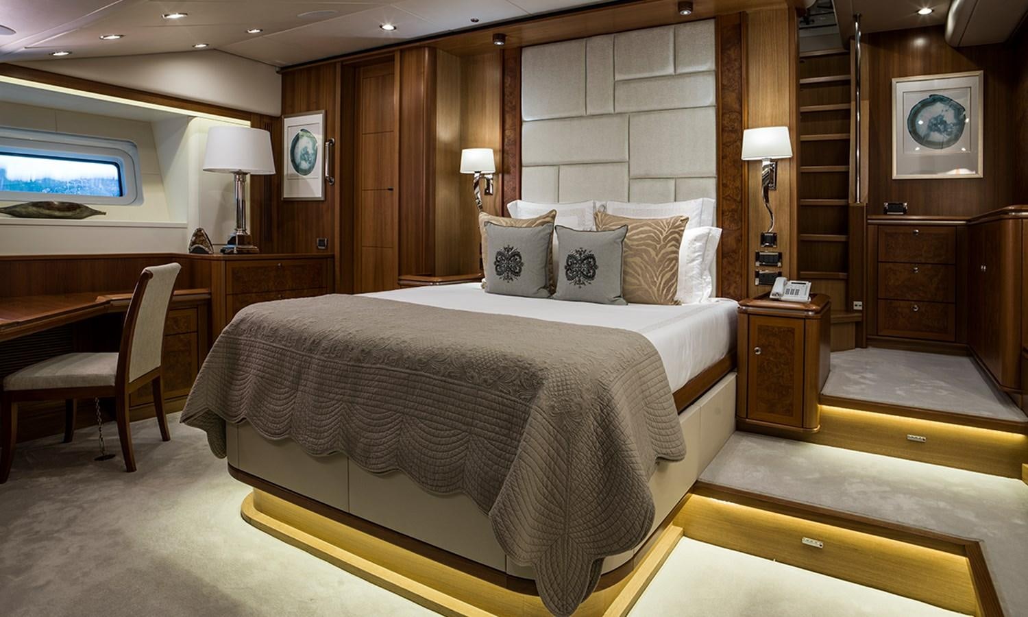 a bedroom with a bed and desk aboard TWILIGHT Yacht for Sale