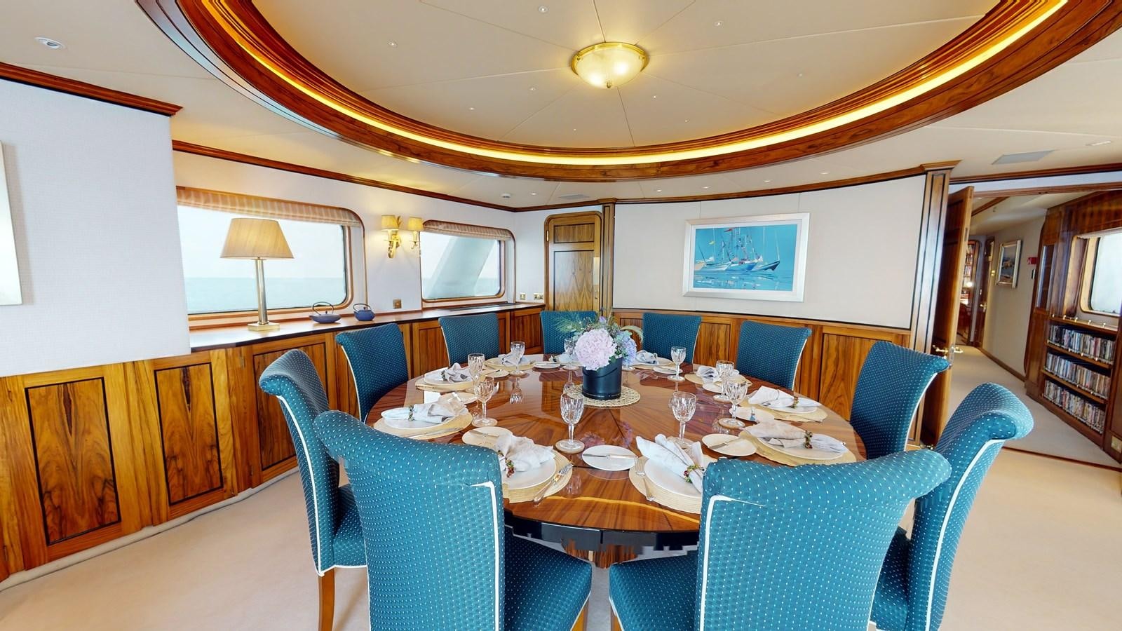 a dining room with blue chairs aboard WILAMINA Yacht for Sale