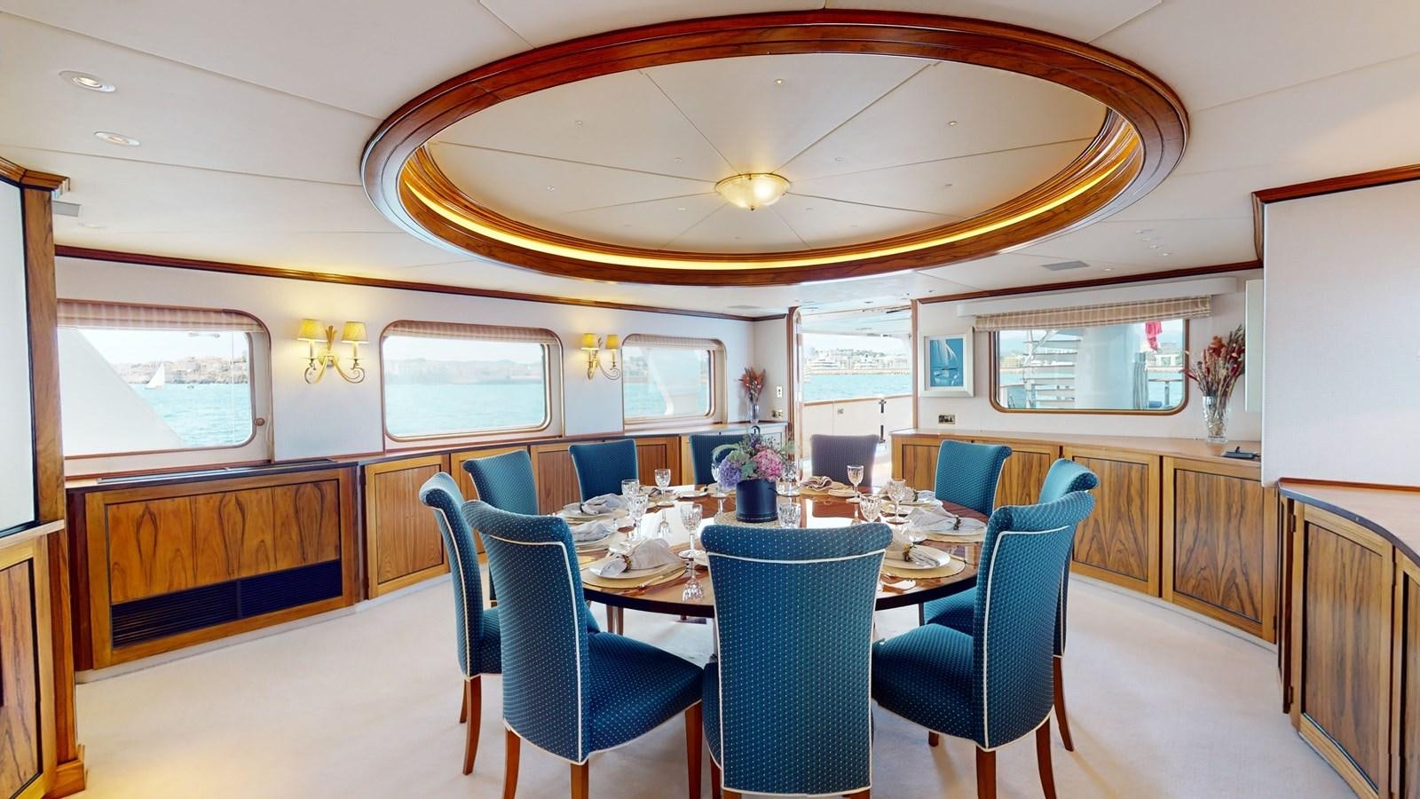 a dining room with blue chairs aboard WILAMINA Yacht for Sale