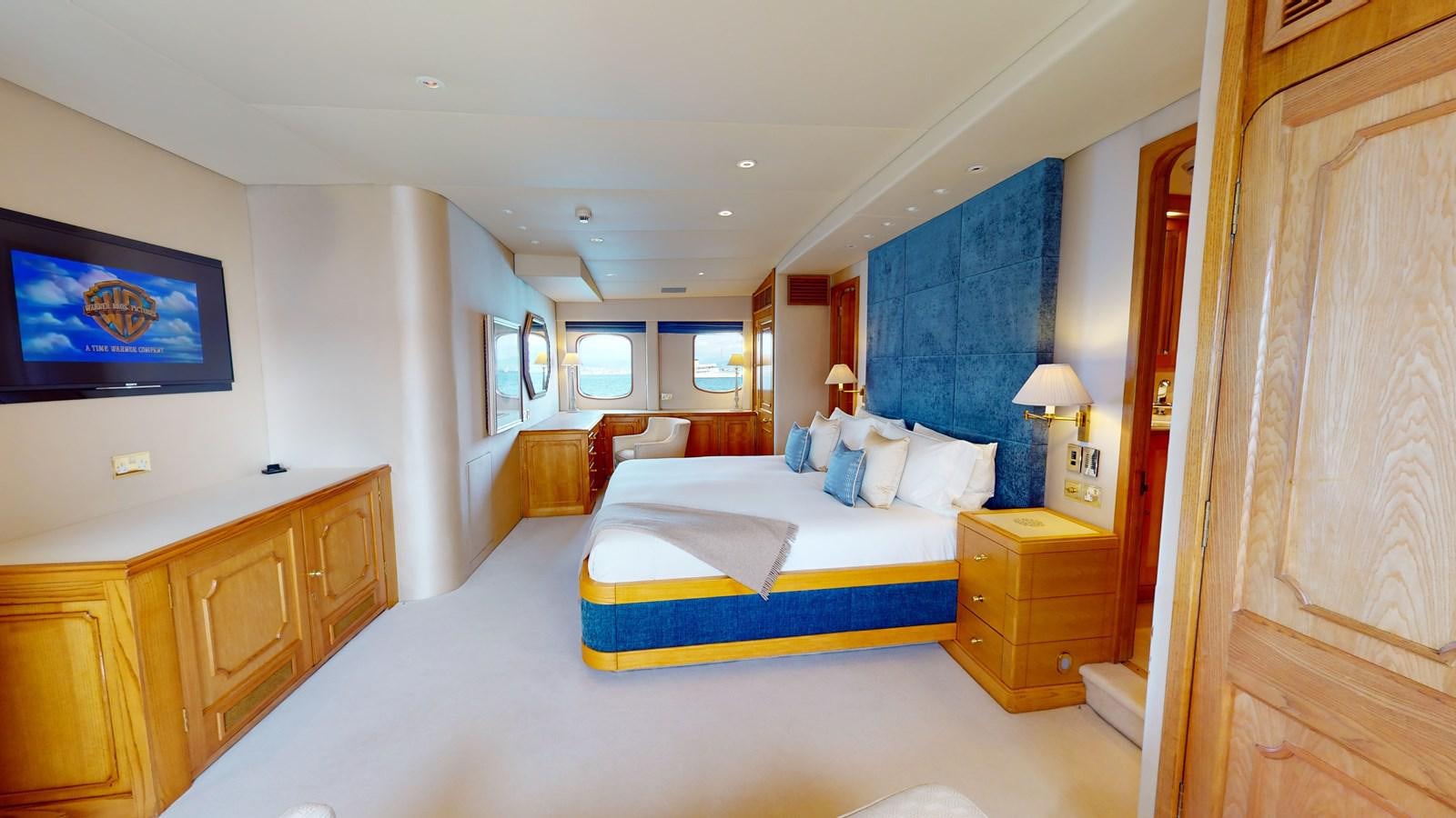 a bedroom with a bed and a tv on the wall aboard WILAMINA Yacht for Sale