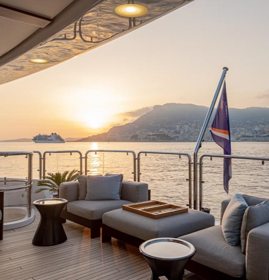 a lounge area with a large body of water and a large umbrella aboard EDESIA Yacht for Charter