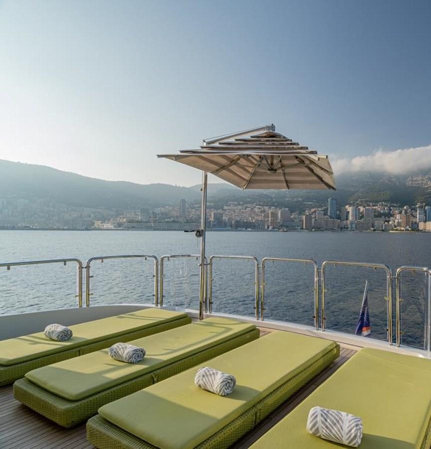 a deck with a table and umbrella aboard EDESIA Yacht for Charter