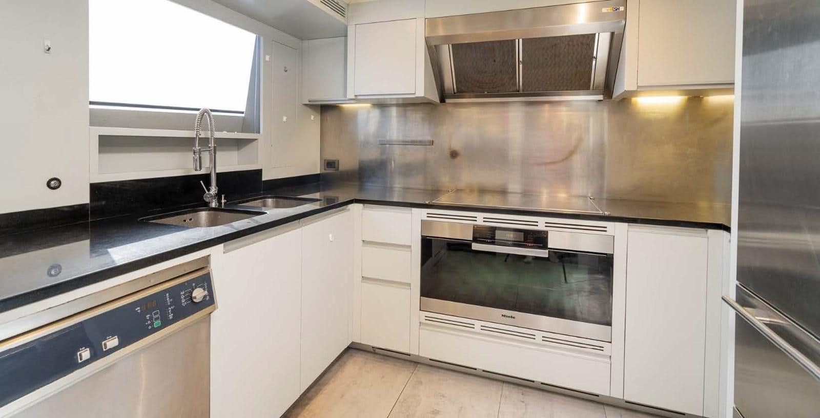 a kitchen with white cabinets aboard EDESIA Yacht for Charter
