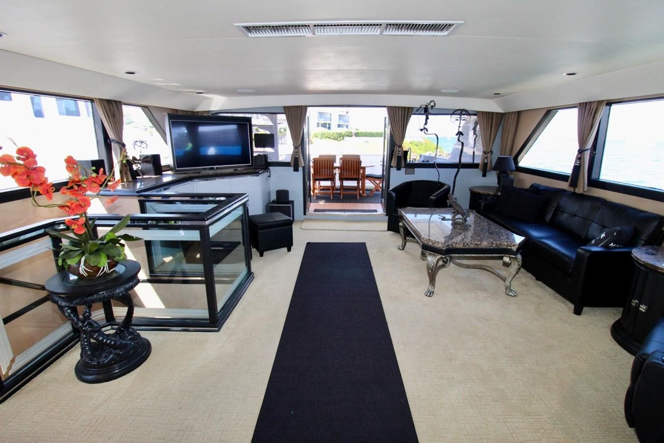a living room with a black couch and a black coffee table aboard PANACHE Yacht for Sale