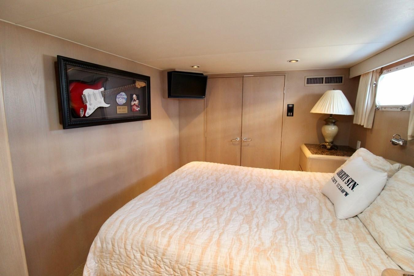 a hotel room with a bed and tv aboard PANACHE Yacht for Sale