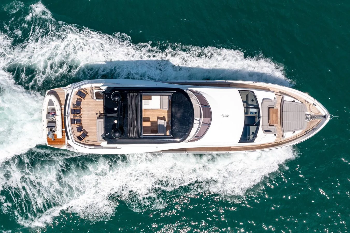 Aerial view of a sleek yacht cruising through the water, showcasing its spacious deck and elegant design. aboard SUNSEEKER Yacht for Sale