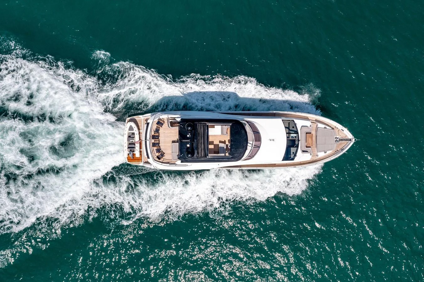 A sleek yacht cruises through the water, leaving a trail of white wake behind. aboard SUNSEEKER Yacht for Sale