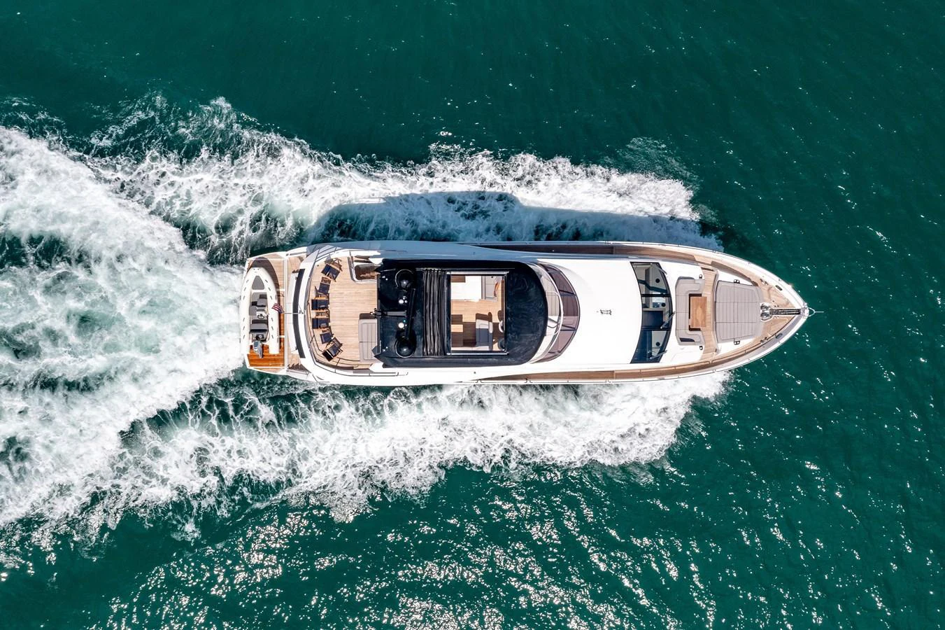 A sleek yacht cruises through the water, showcasing its elegant design from an aerial perspective. aboard SUNSEEKER Yacht for Sale