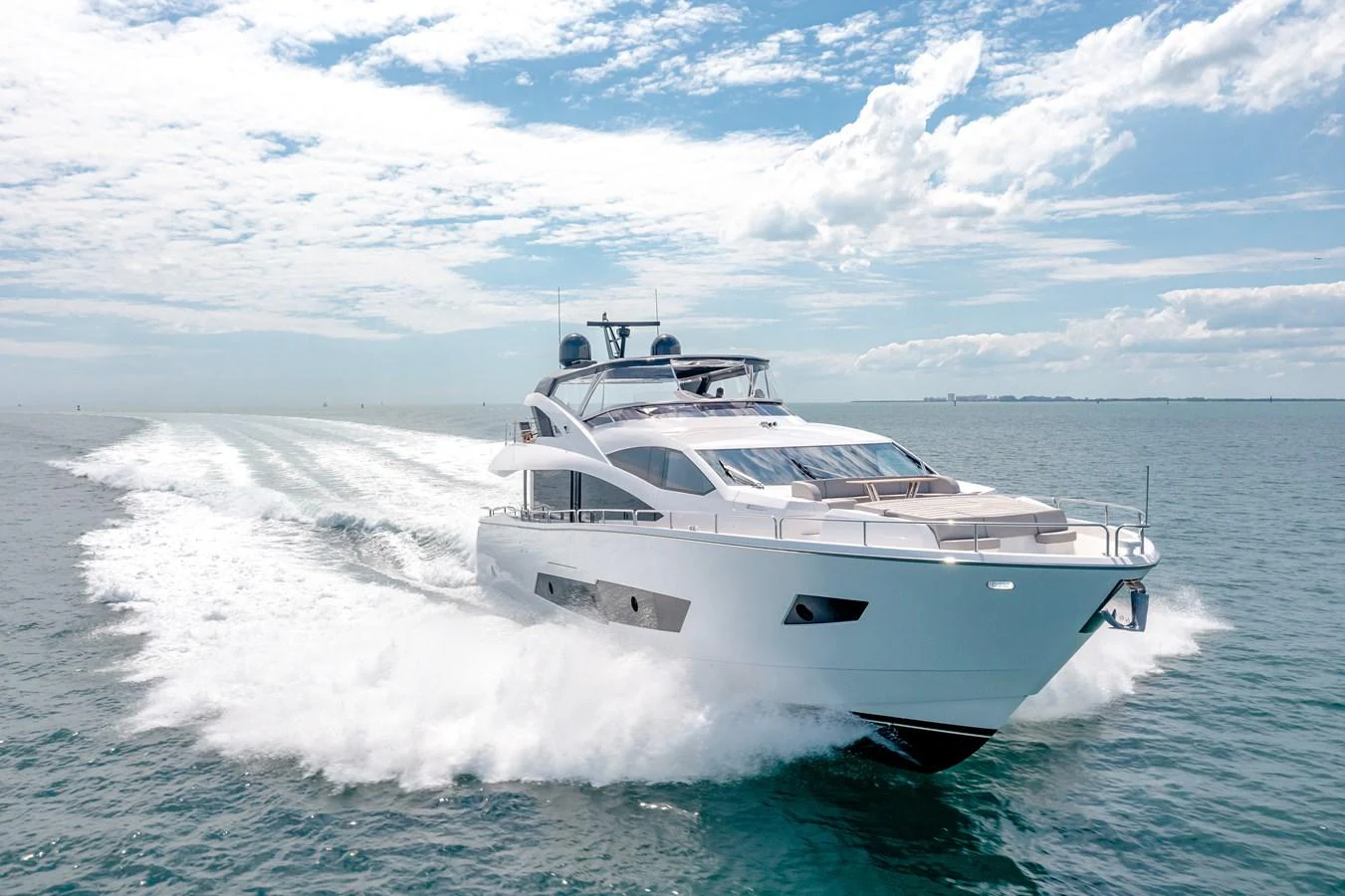 A sleek and modern yacht cruises swiftly across the open sea under a bright, clear sky. aboard SUNSEEKER Yacht for Sale