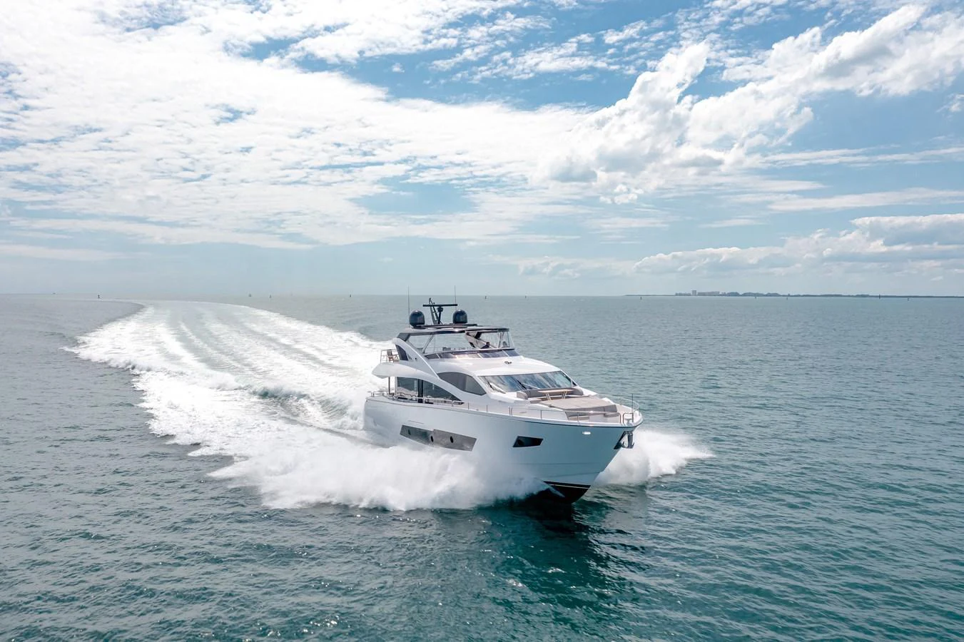 A sleek yacht cruises swiftly across open waters under a bright, clear sky. aboard SUNSEEKER Yacht for Sale