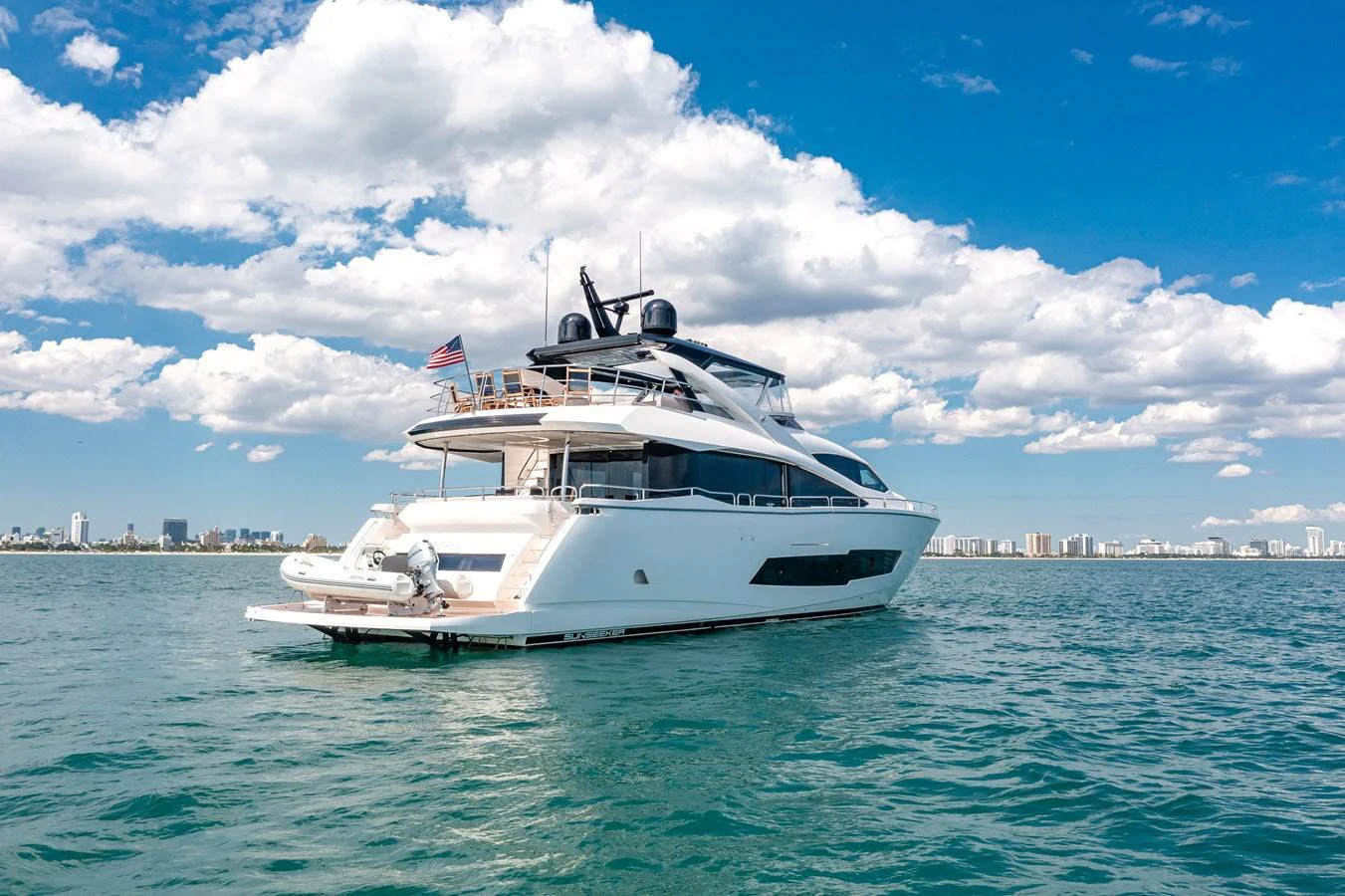 A sleek and modern yacht cruising on calm waters under a bright blue sky. aboard SUNSEEKER Yacht for Sale