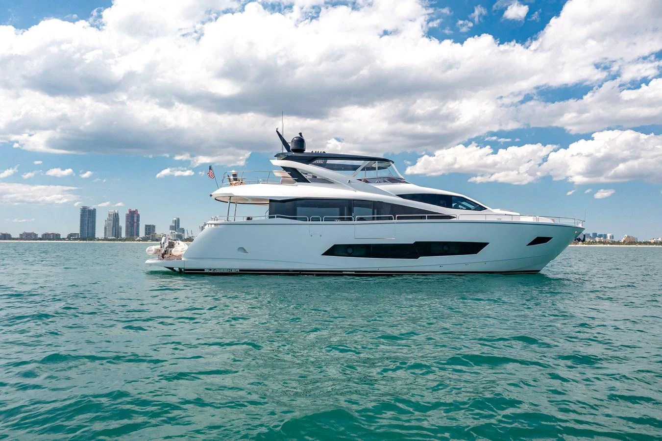 A sleek and modern yacht cruising on calm waters under a partly cloudy sky. aboard SUNSEEKER Yacht for Sale