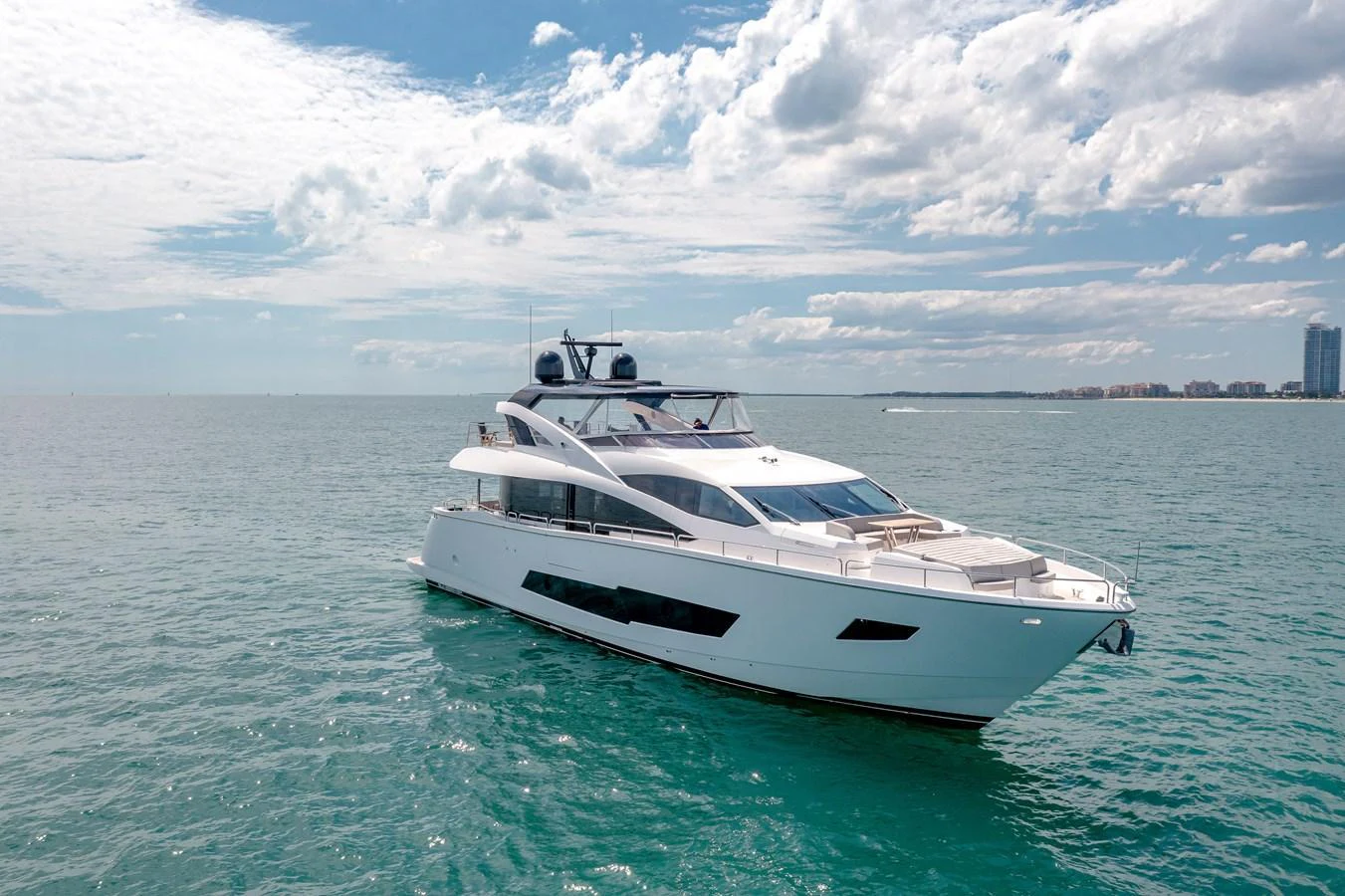 A sleek and modern yacht cruising on calm waters under a partly cloudy sky. aboard SUNSEEKER Yacht for Sale