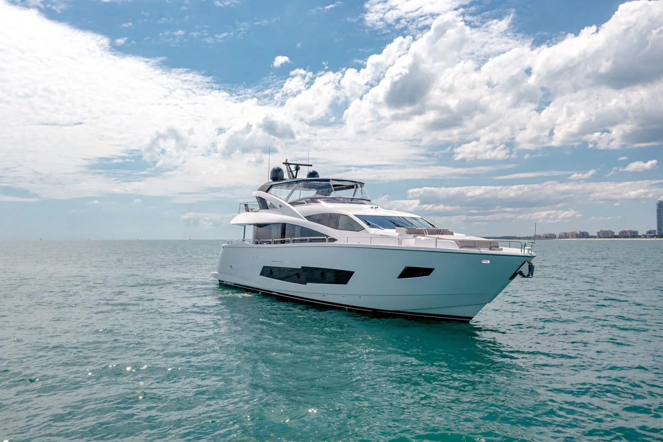 A sleek and modern yacht glides gracefully on calm waters under a partly cloudy sky. aboard SUNSEEKER Yacht for Sale
