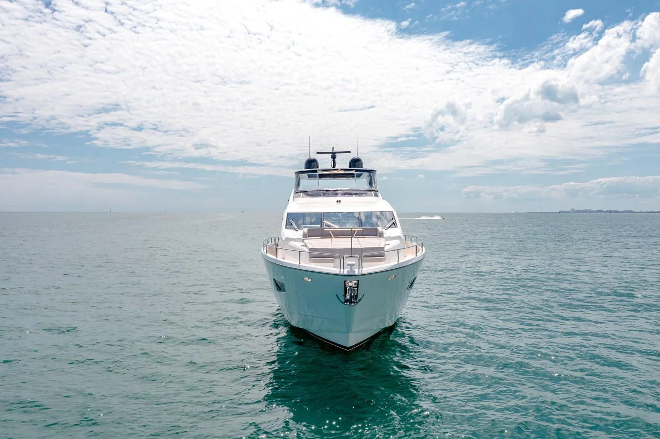 A sleek yacht cruises on a calm sea under a bright, partly cloudy sky. aboard SUNSEEKER Yacht for Sale