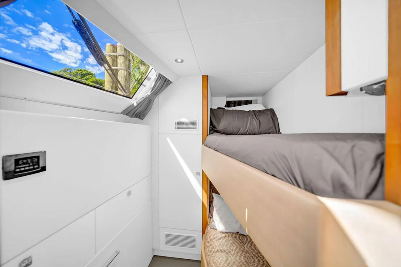 A cozy cabin with bunk beds and a skylight offering a view of the sky and greenery. aboard SUNSEEKER Yacht for Sale