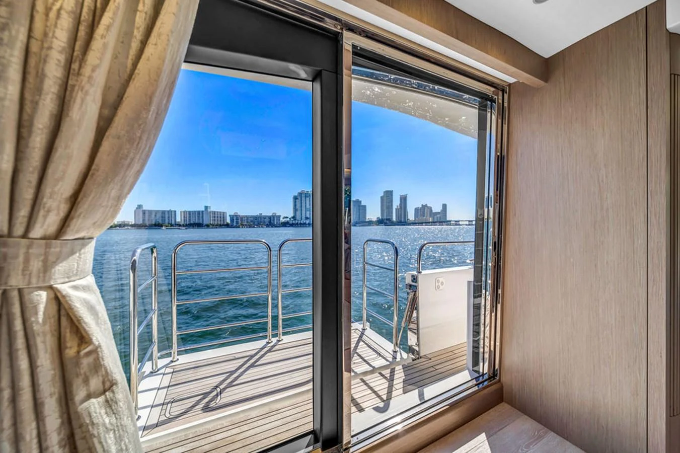 A serene view from the cabin, showcasing the water and cityscape through large windows. aboard SUNSEEKER Yacht for Sale