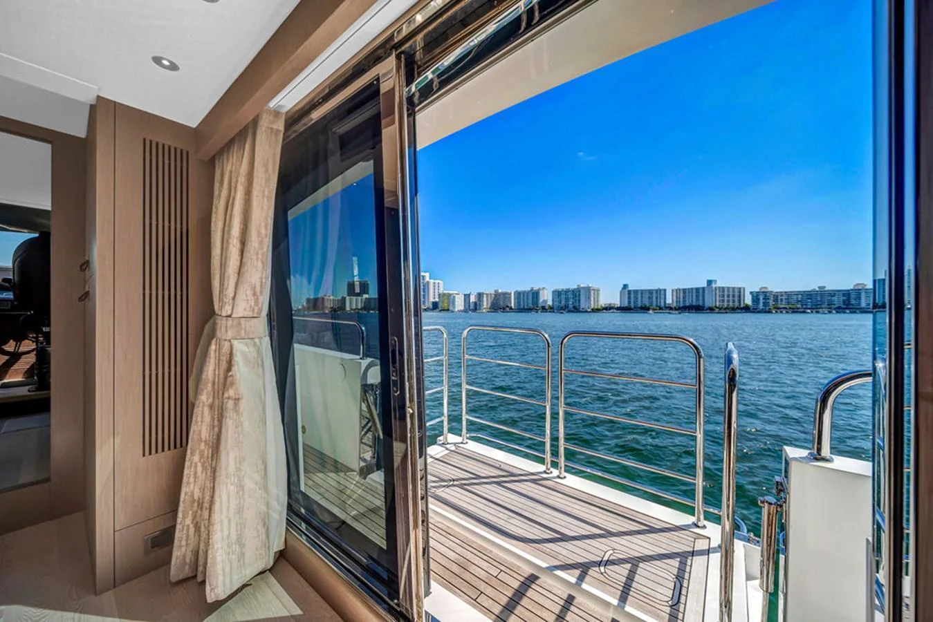 A luxurious interior space opens up to a scenic view of the water and city skyline. aboard SUNSEEKER Yacht for Sale