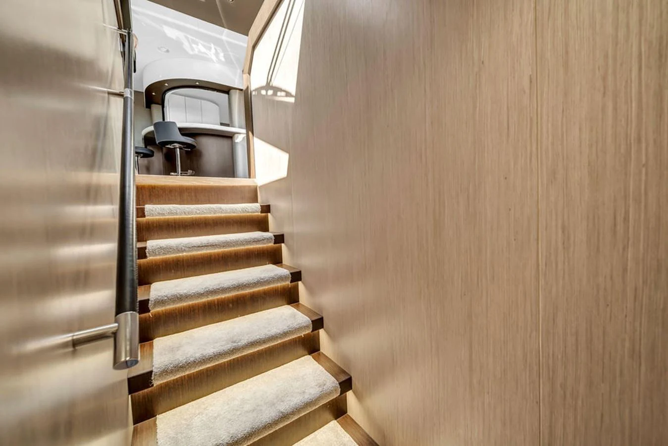 A well-lit staircase with wooden paneling and carpeted steps leads to an upper level. aboard SUNSEEKER Yacht for Sale