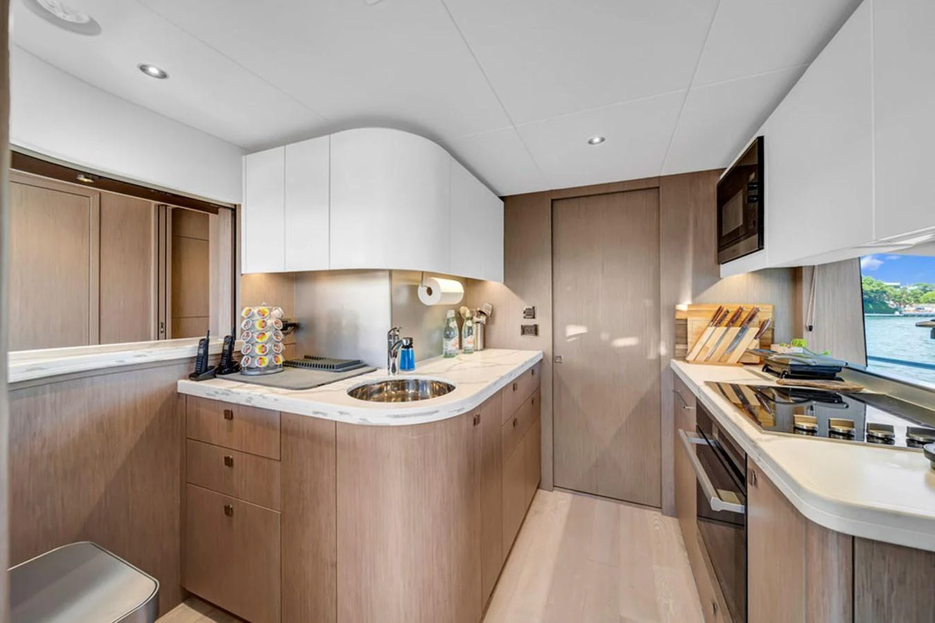The yacht's galley features modern appliances and sleek cabinetry with a view of the water. aboard SUNSEEKER Yacht for Sale