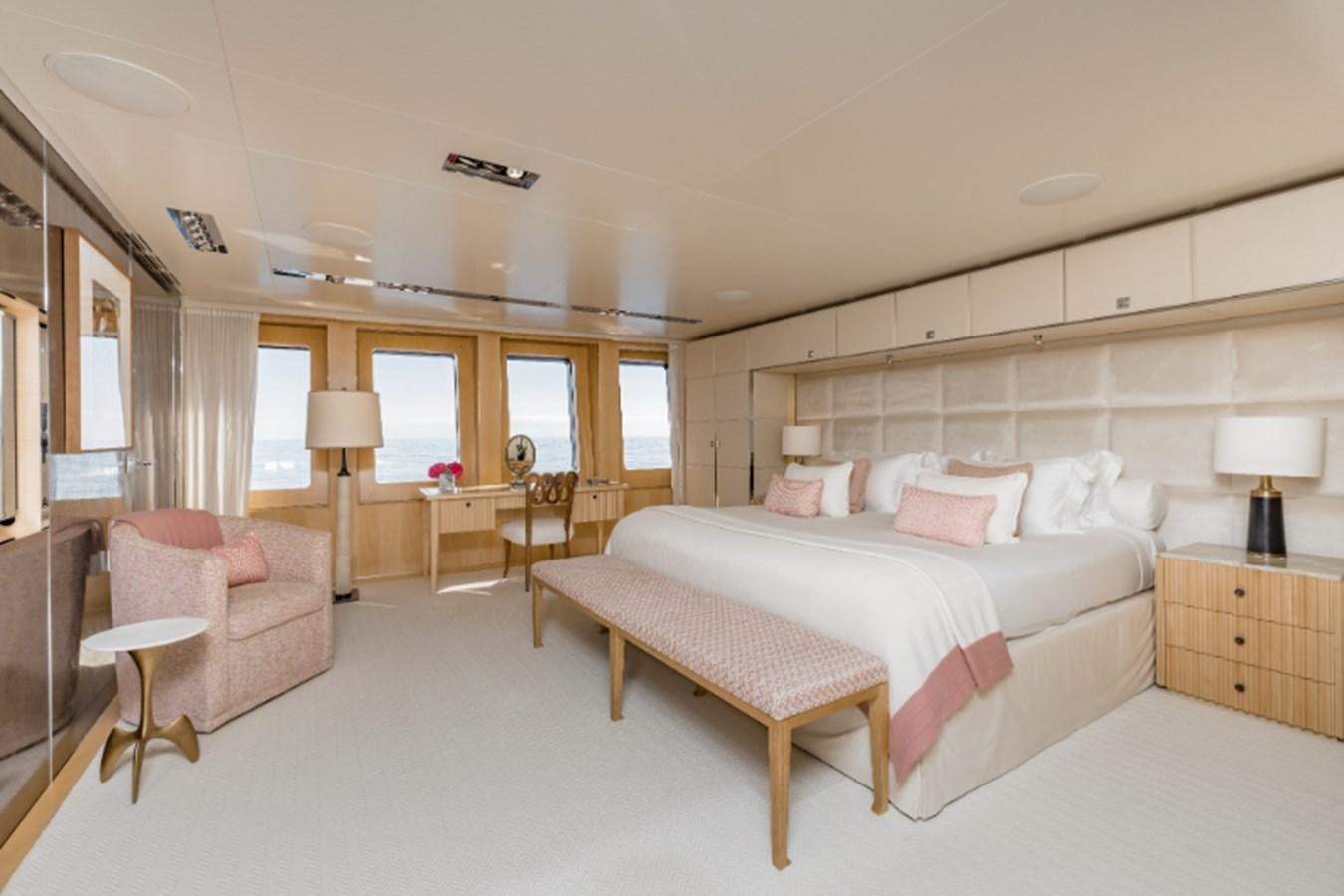 a bedroom with a bed and a table aboard LOON Yacht for Sale