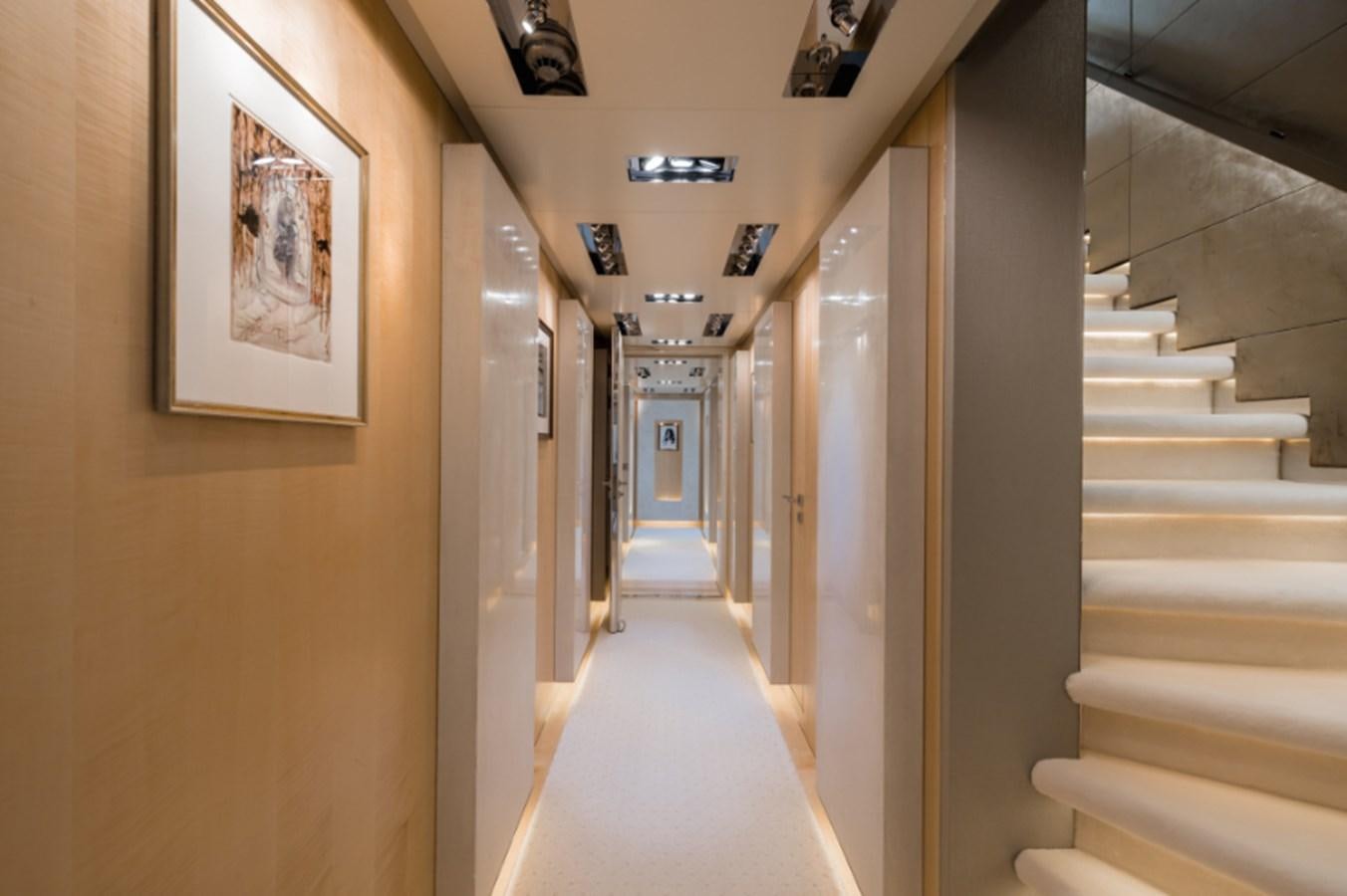 a hallway with a staircase and pictures on the wall aboard LOON Yacht for Sale