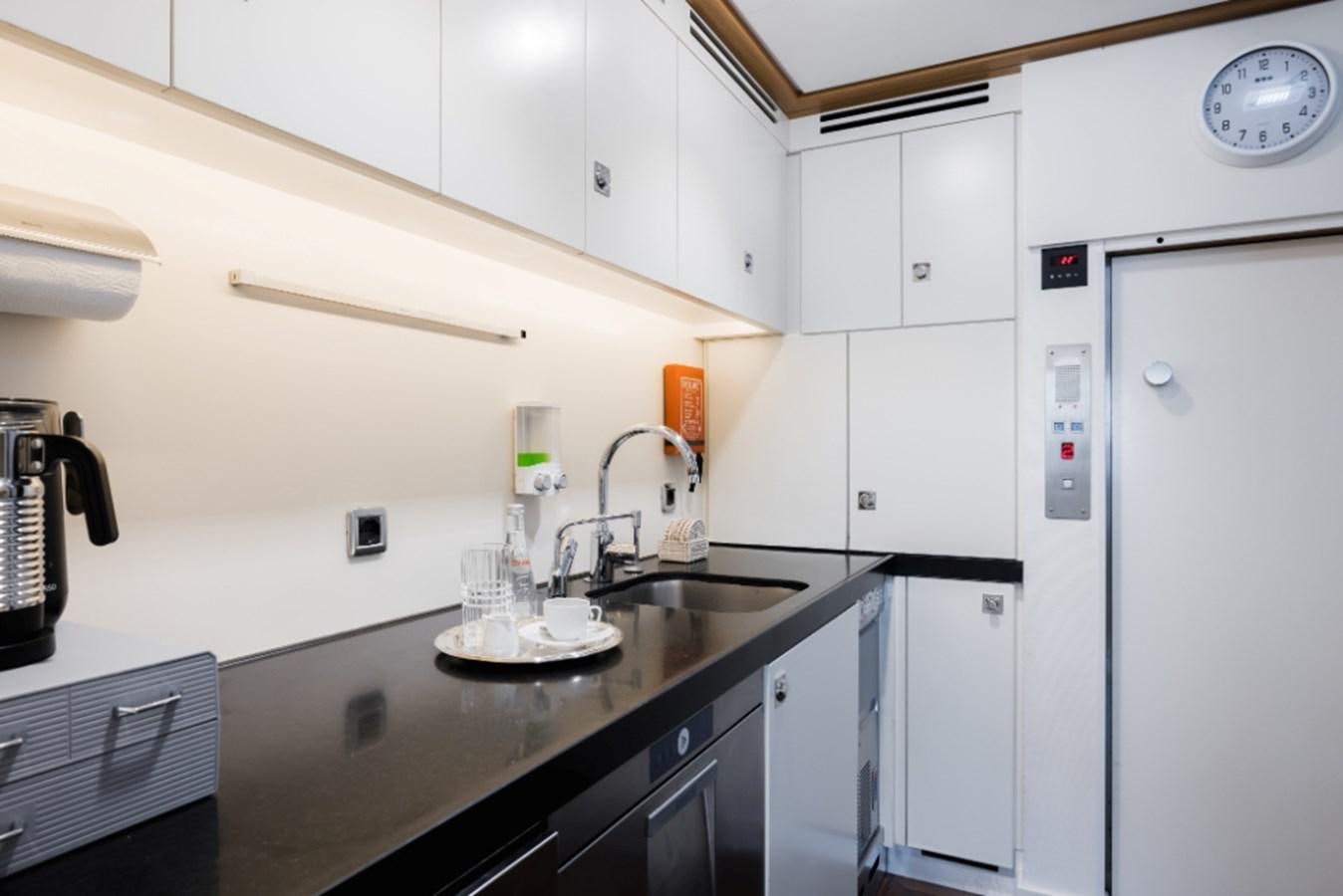 a kitchen with white cabinets aboard LOON Yacht for Sale