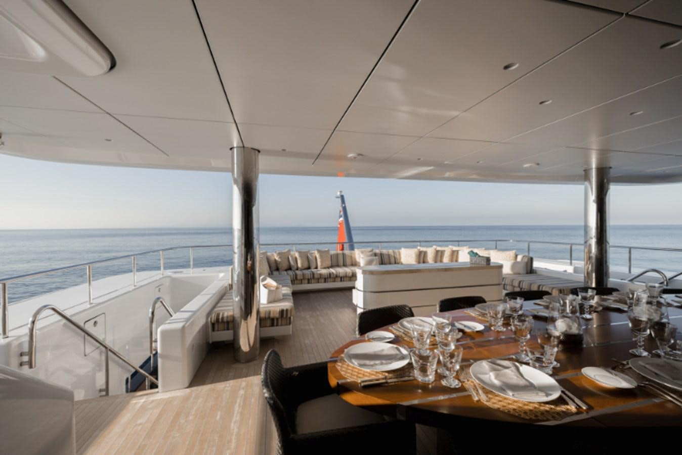 a table set for a dinner on a balcony overlooking the ocean aboard LOON Yacht for Sale
