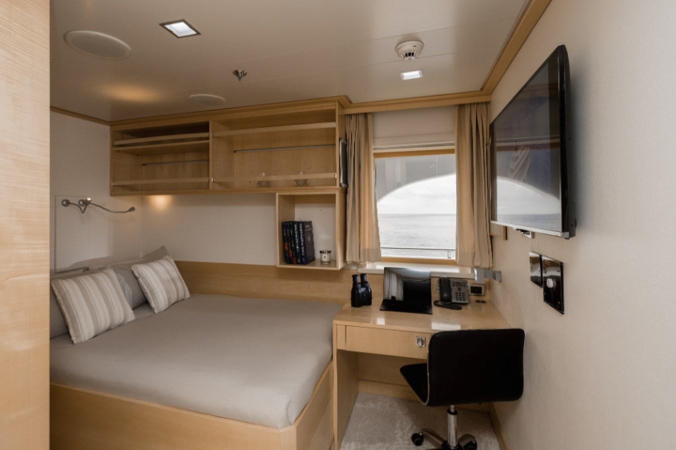 a room with a bed and a desk aboard LOON Yacht for Sale