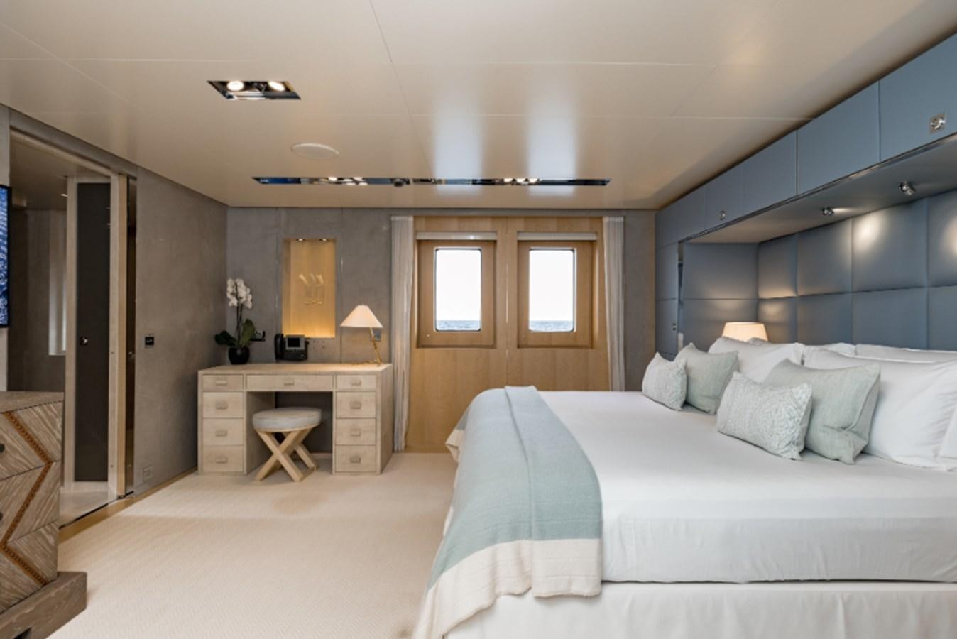 a bedroom with a bed and a desk aboard LOON Yacht for Sale