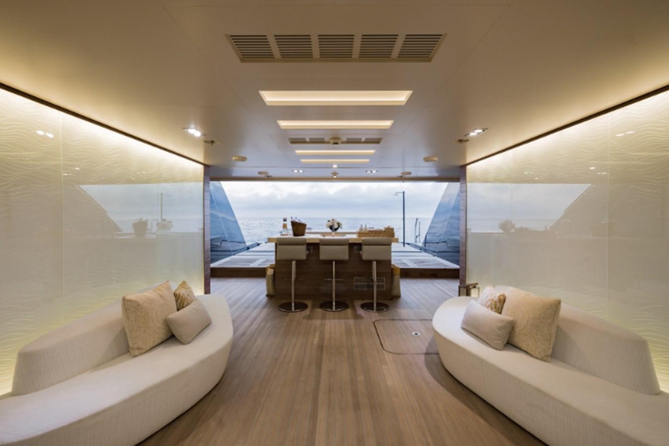 a room with a couch and a table and a large window aboard LOON Yacht for Sale