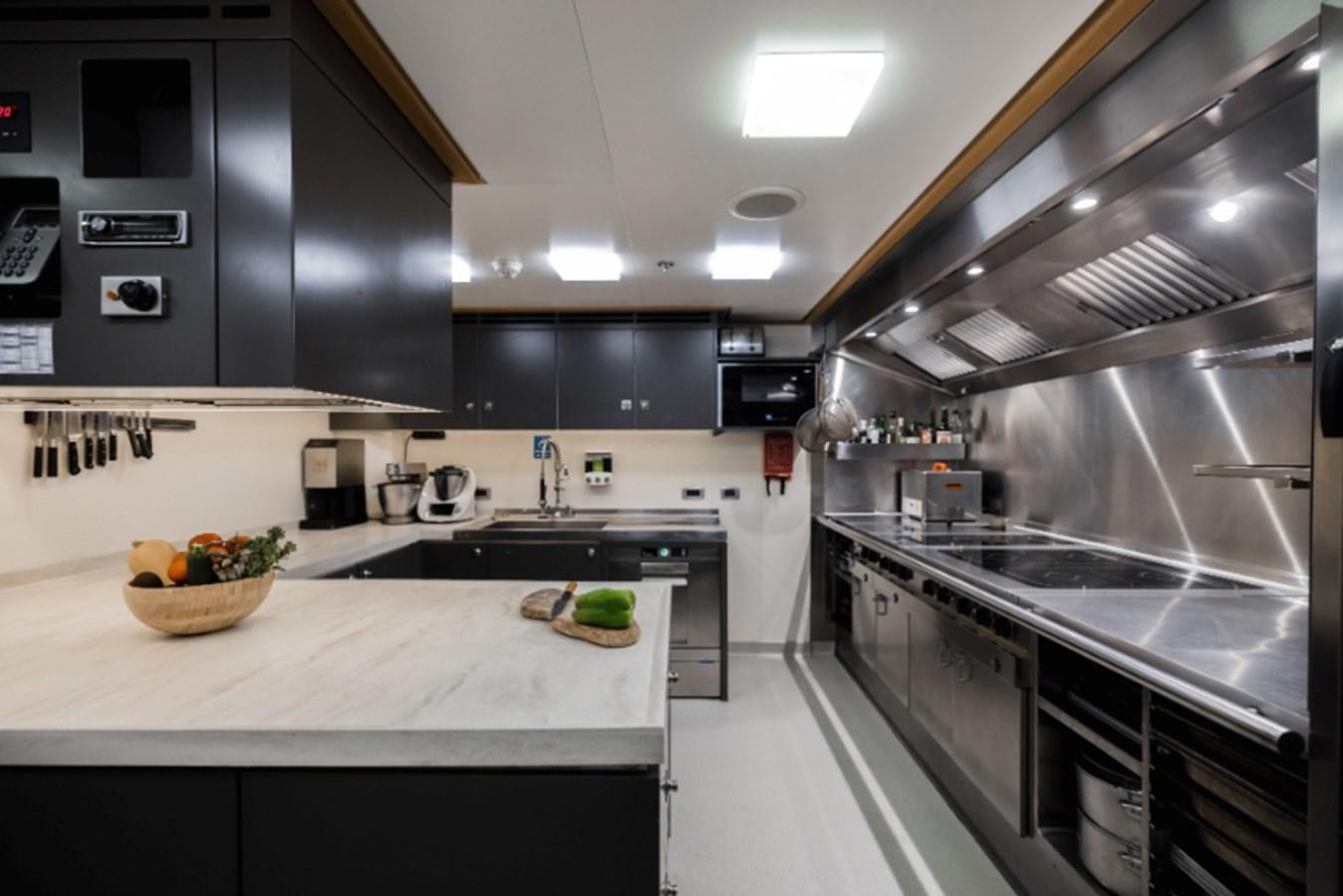 a kitchen with a large stainless steel oven and island aboard LOON Yacht for Sale