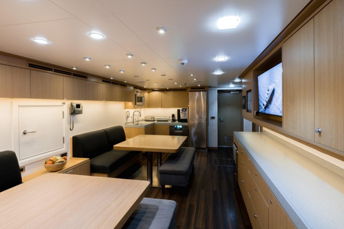 a kitchen with a table and chairs aboard LOON Yacht for Sale