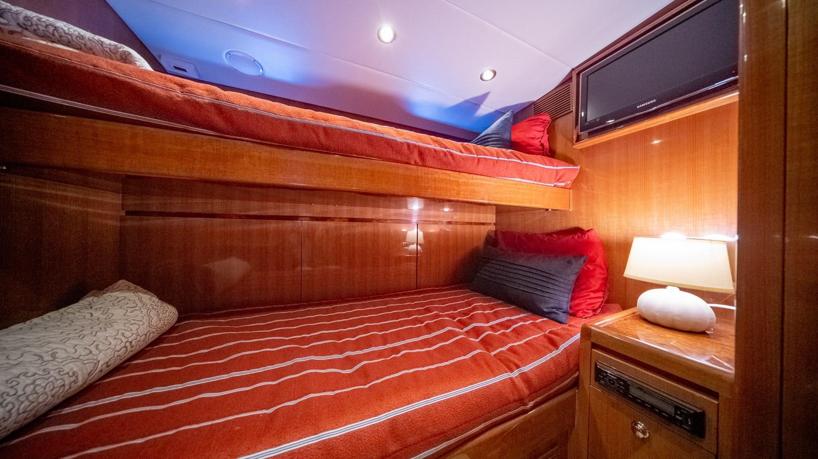 a bed with a red and white comforter and pillows aboard SEA CZAR Yacht for Sale